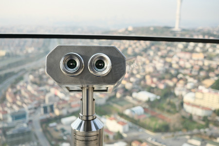 城市钱币摄影照片_俯瞰城市的投币式双筒望远镜，