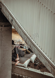 在项目工地桥下的垫子上工作休息时，精疲力尽的建筑工人睡着了。