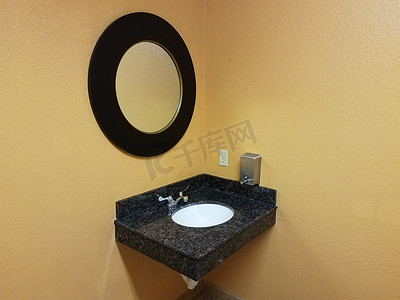 反光的镜子摄影照片_洗手间或带水槽和镜子的浴室的黄色墙壁
