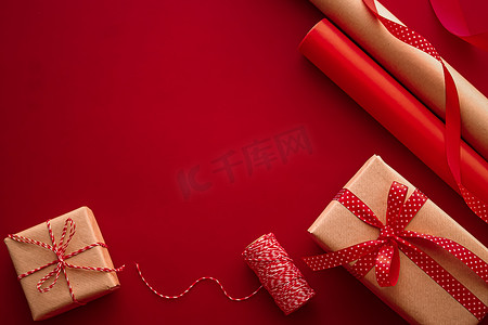红色背景礼物礼盒摄影照片_礼品准备、生日和节日礼物赠送、工艺纸和红色背景礼盒丝带作为包装工具和装饰品、DIY 礼物作为节日平躺设计