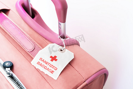 带有纸质标签的红色手提箱，表明行李已经过消毒。