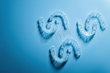 固定的空间摄影照片_蓝色背景、牙科保健和健康上呈图案状的塑料牙套