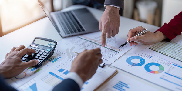 商业投资顾问团队分析公司年度财务报告，使用笔记本电脑、商业和金融概念处理文档饼图和圆环图