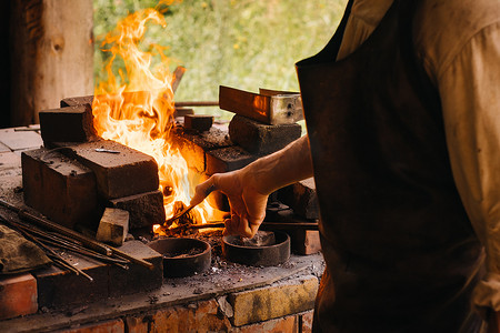 铁匠在村里自制的炉子里用高温硬化钢材