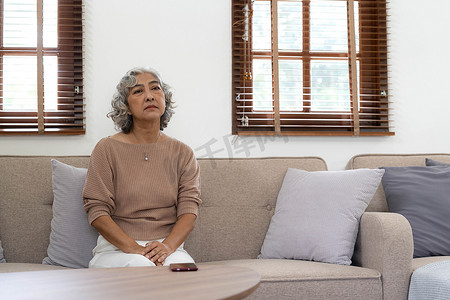 沮丧孩子摄影照片_一位孤独的老年妇女正在等待和思考她家人的旧记忆，她会再次拜访她，孤独和沮丧的抑郁老人独自坐着，思念，怀旧，纪念