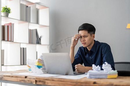 地签摄影照片_疯疯癫癫的男员工坐在办公室工作场所，周围到处都是便签，愤怒地大喊大叫，对截止日期和办公室压力大的工作感到愤怒