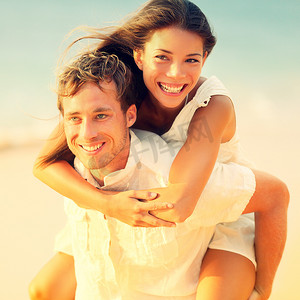 浪漫的情侣在海滩上背负着乐趣