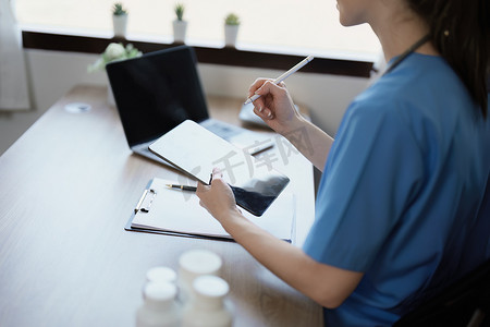一位女医生在治疗前使用平板电脑和分析患者病情的文件的肖像。