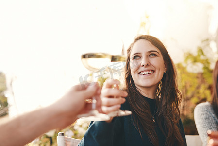 假期在户外餐厅与朋友聚会时，葡萄酒、快乐和女人举杯庆祝。