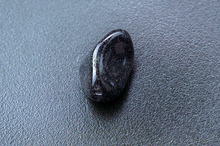 在黑暗的背景的自然矿物岩石标本擦亮的黑玛瑙宝石