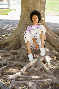 思念的摄影照片_坐在树附近的沉思黑人妇女