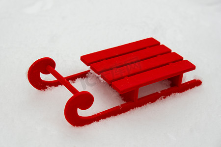 雪免费摄影照片_在美丽的冬日雪背景上的小红色雪橇。