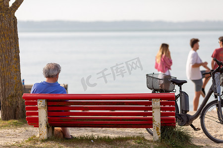 老人看海摄影照片_坐在长椅上看海的老人