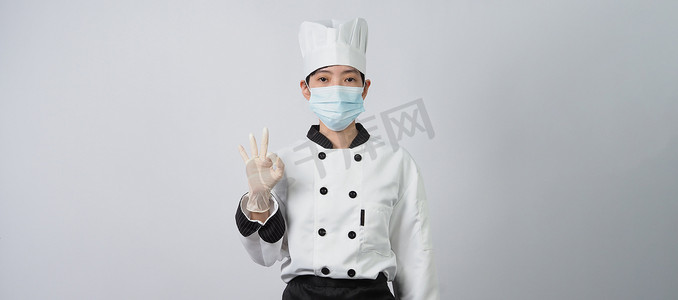 身着制服、戴着医用面罩和手套的亚洲女厨师。