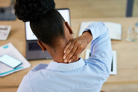 黑人女性、颈部疼痛和疲劳，在疲倦或倦怠时在办公桌上伸展或按摩。