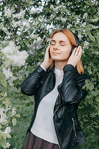 一个红发少女戴着耳机听音乐，耳机是通过电话配置的。