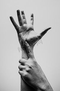 一只手势摄影照片_年轻的手，一只手抓住另一只手，黑白相间，质感十足