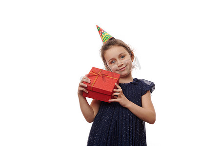 漂亮的孩子，可爱的生日女孩拿着一个时尚的红色礼盒，里面有惊喜，与白色背景隔离。