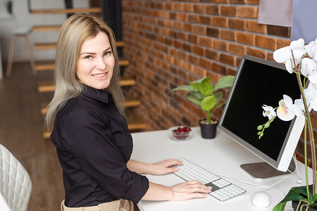 成功的女性图形设计师在办公室工作过程中观看关于电脑创意的教程。