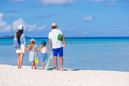 热带海滩上一个年轻家庭的背影