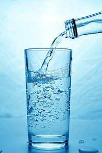 新鲜干净的水从瓶子里倒进玻璃杯里。