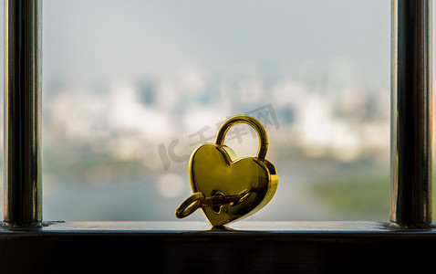 不锈钢阳台栏杆上的金色心形爱心挂锁和钥匙。