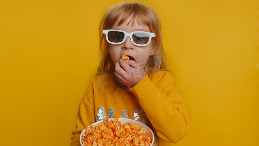 电影视频片摄影照片_兴奋的小女孩吃爆米花，看电视连续剧，体育游戏，电影，在线社交媒体电影