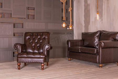 棕色真皮扶手椅和复古真皮沙发。