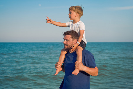 父子一起在外面展示手指海平线背 男人孩子度过假期享受夏天