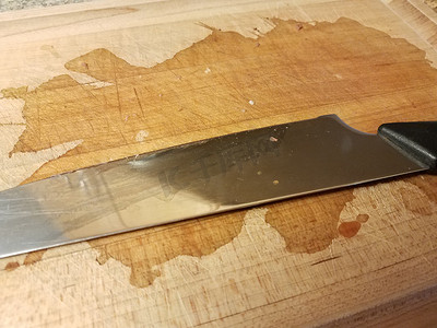金属刀摄影照片_带污渍的木切板上的金属刀