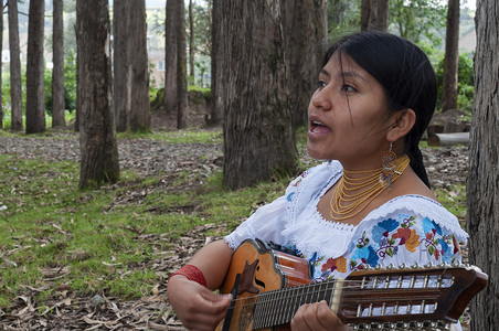 一位年轻的土著妇女在森林里唱歌和弹奏曼陀林的特写