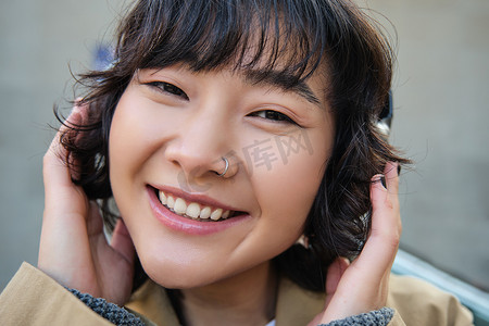 快乐女人的画像，戴耳机的韩国女孩，戴耳机听音乐，享受耳机的声音，笑着笑