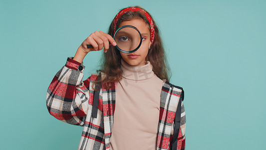 拿放大镜小女孩摄影照片_调查员十几岁的小女孩拿着放大镜靠近脸，大眼睛搜索分析