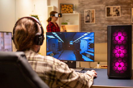 深夜在客厅玩功能强大的 PC 的专业视频游戏玩家的后视图