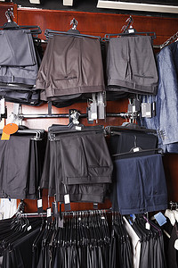 商店衣架上挂着的各种正式裤子