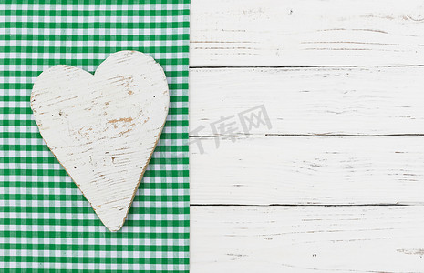 在绿色织品和白色木头背景的白色心脏
