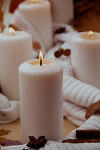 感恩节和 Hello Fall 万圣节概念 在窗台上舒适的家中庆祝秋季假期 Hygge 审美氛围 秋叶香料和蜡烛在温暖的黄色灯光下的针织白色毛衣上