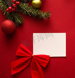 感谢信背景摄影照片_圣诞饰品、礼物和装饰品，上面有白色空白的问候语或名片，或者在节日的红色背景上写上感谢信，作为节日快乐的平板