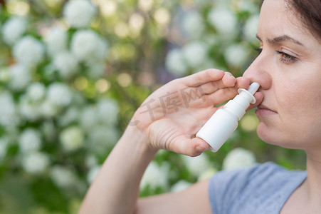 白种女人在公园散步时使用喷鼻剂。
