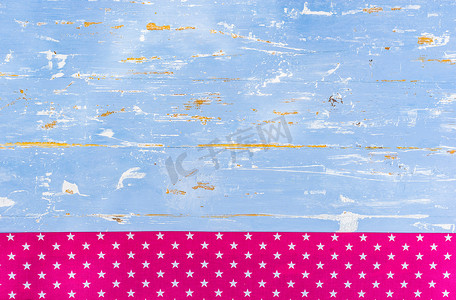 带粉色星形织物边框的质朴蓝色木质背景