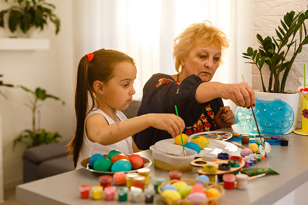 祖母和孙女玩复活节彩蛋，复活节时间画鸡蛋。