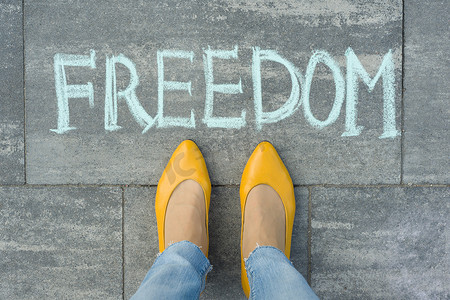 灰色人行道上写有文字自由的女性脚