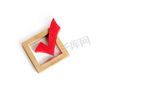 对公摄影照片_用于在白色背景上对选举进行投票的红色木制复选标记。