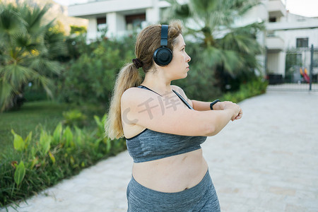 穿着运动服的可爱胖女人正在健身户外侧视肖像。