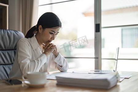 体贴焦虑的亚洲女商人将目光移开，思考解决工作中的问题，担心严肃的年轻女性担心做出艰难的决定，在思考中迷失方向，反映坐在笔记本电脑上