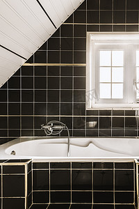 黑色瓷砖浴室中的白色浴缸