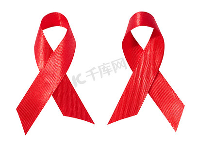 预防艾滋病标志摄影照片_一条蝴蝶结形式的丝绸红丝带在白色背景上被隔离，这是抗击艾滋病的象征，也是团结和支持的标志。