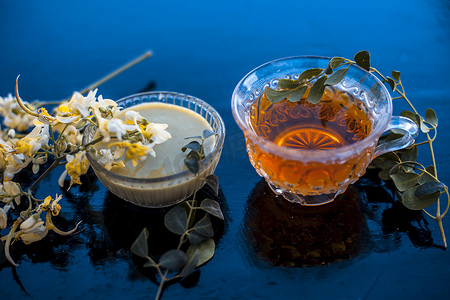 种茶摄影照片_木质表面上的 Saragava 或鸡腿或辣木花及其糊状物和草本提取茶。