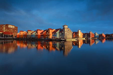 色建筑摄影照片_阳光下水面上的多色建筑