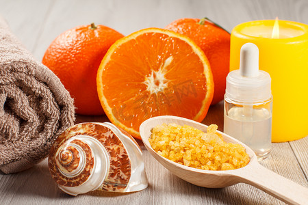 用两个完整的橙子切橙子、毛巾、贝壳、装有芳香油的瓶子